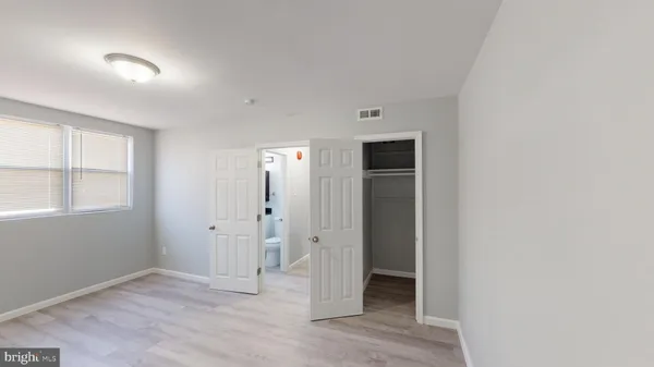 an empty room with windows and closet