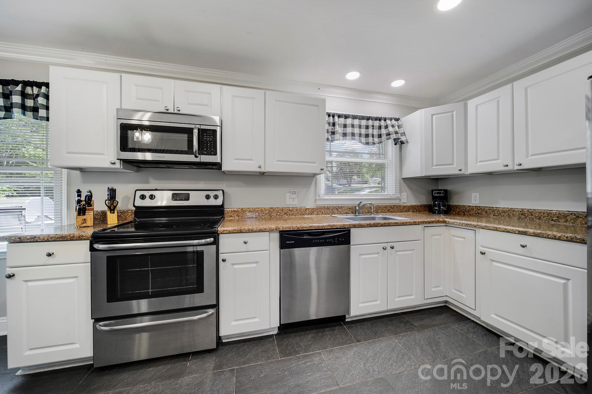 100 Privette Street Fort Mill, SC 29715 - Photo 10 of 25 a kitchen with stainless steel appliances granite countertop a sink a stove a microwave and cabinets