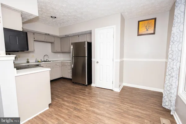a kitchen with stainless steel appliances a refrigerator sink and microwave