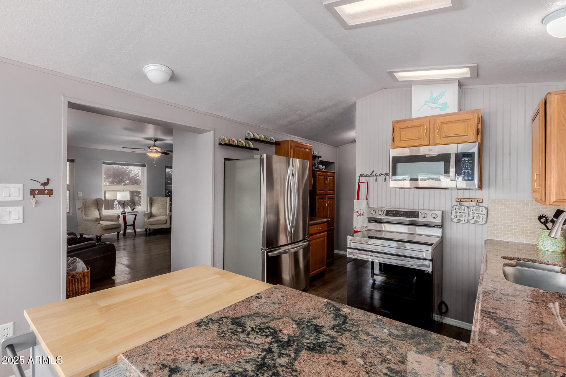 17200 West Bell Road, Unit 1233 Surprise, AZ 85374 - Photo 14 of 41 a kitchen with stainless steel appliances kitchen island granite countertop a refrigerator stove and sink