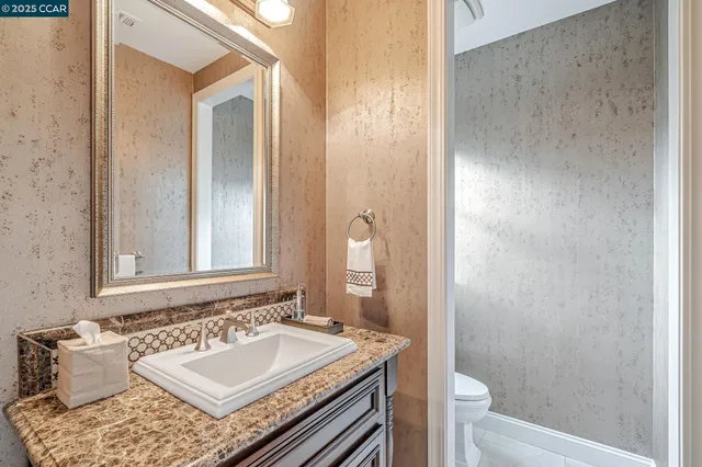 a kitchen with stainless steel appliances granite countertop a stove a refrigerator a kitchen island a dining table and chairs