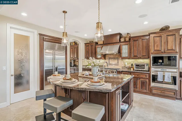 a kitchen with stainless steel appliances granite countertop a sink stove and cabinets