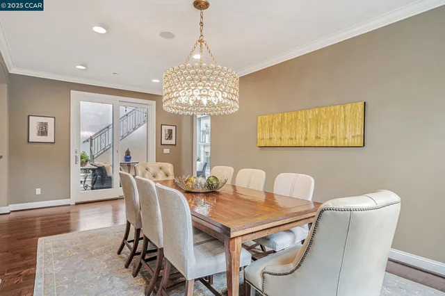 a room with stainless steel appliances kitchen island granite countertop a dining table chairs stove a refrigerator and cabinets