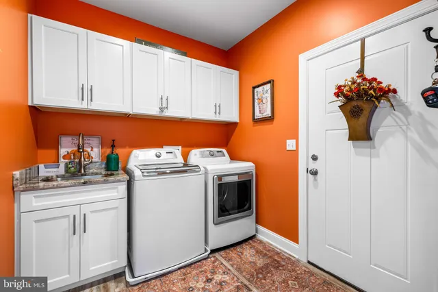 a utility room with sink dryer and washer