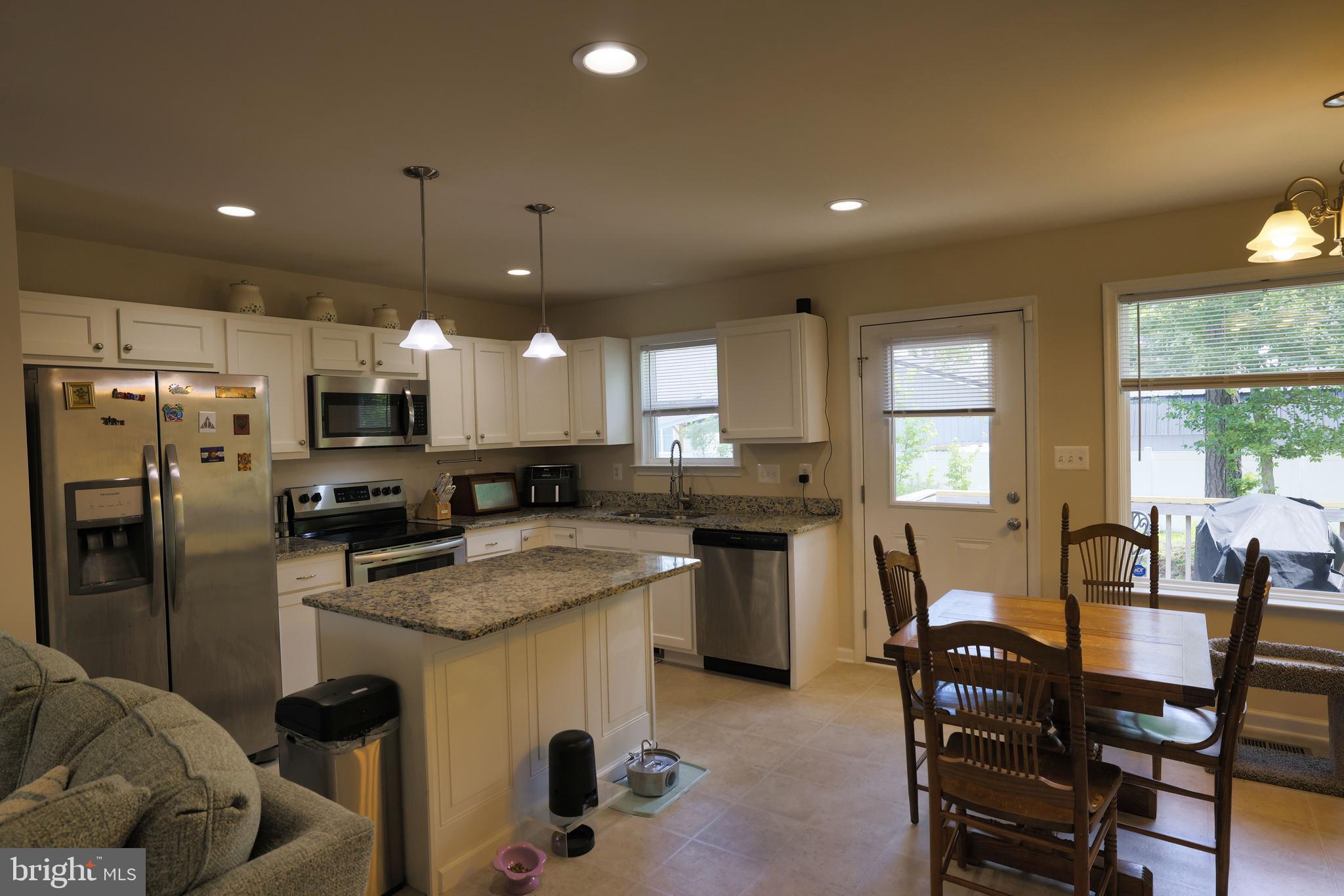 48 Rustic Lane Colonial Beach, VA 22443 - Photo 17 of 47 a kitchen with a table chairs refrigerator and microwave