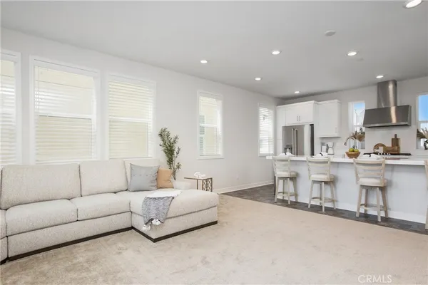 a living room with furniture and kitchen view