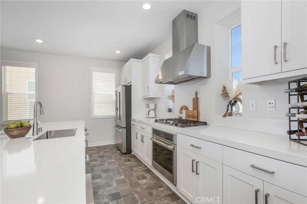 116 Stetson Street Rancho Mission Viejo, CA 92694 - Photo 6 of 45 a kitchen with stainless steel appliances a sink stove and refrigerator
