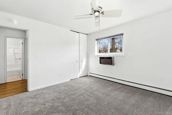 an empty room with windows and fan