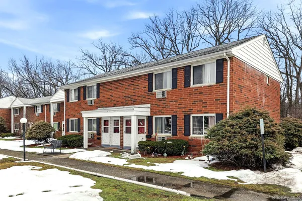 a front view of a house with a yard covered in snow