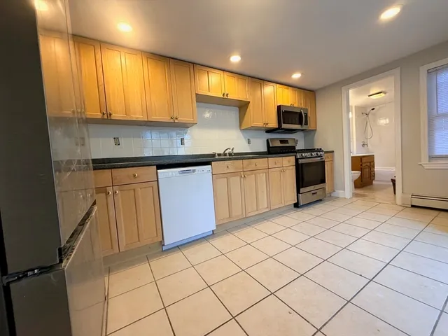 a kitchen with stainless steel appliances granite countertop a refrigerator sink and cabinets