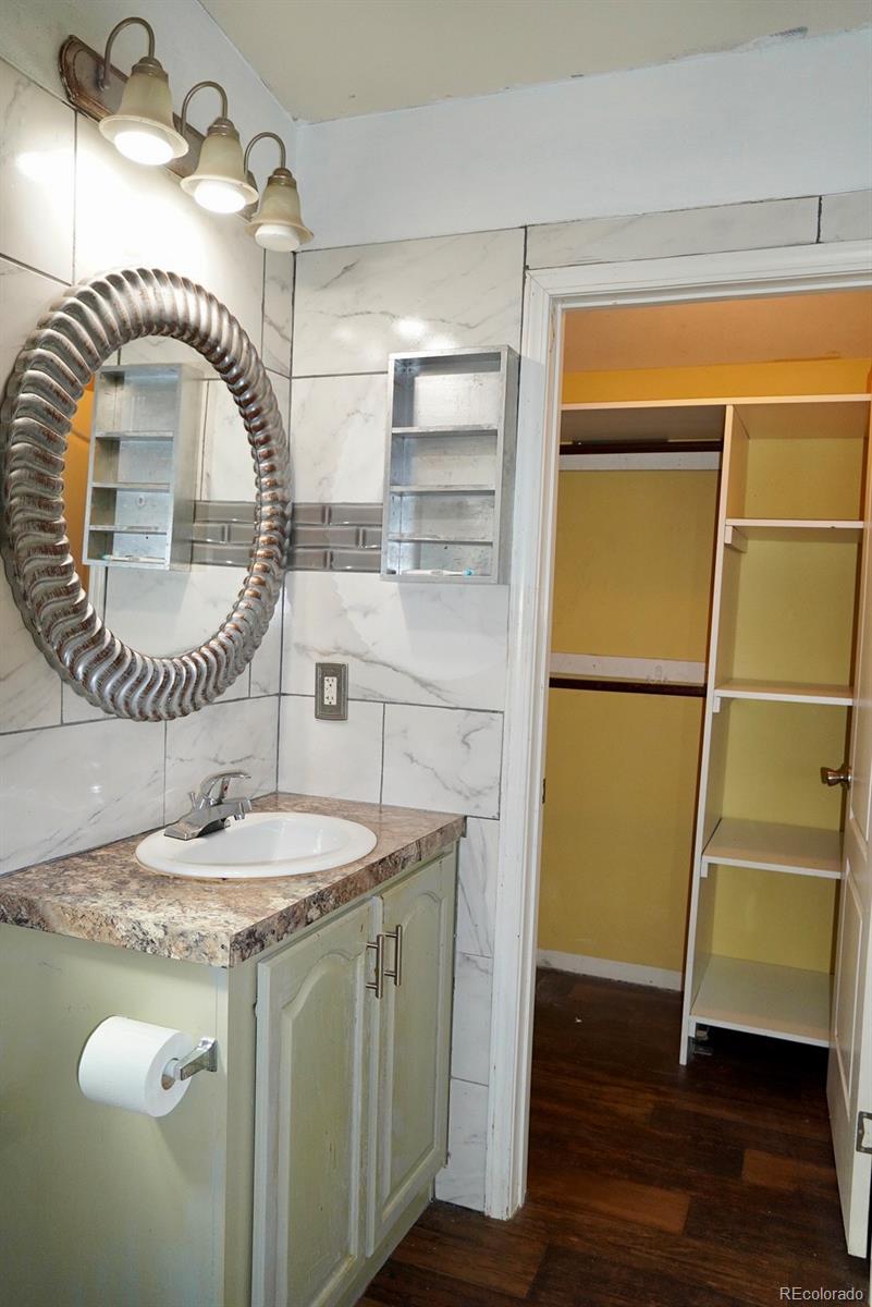 9100 Tejon Street Denver, CO 80260 - Photo 13 of 23 a bathroom with a granite countertop sink a mirror and vanity