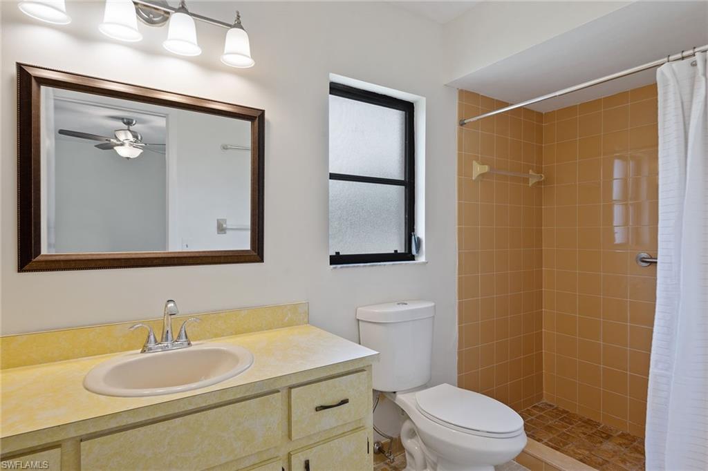 774 99th Avenue North Naples, FL 34108 - Photo 10 of 13 a bathroom with a granite countertop sink toilet a mirror and shower