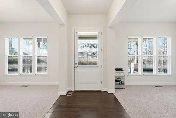 a view of a hallway with wooden floor and a living room