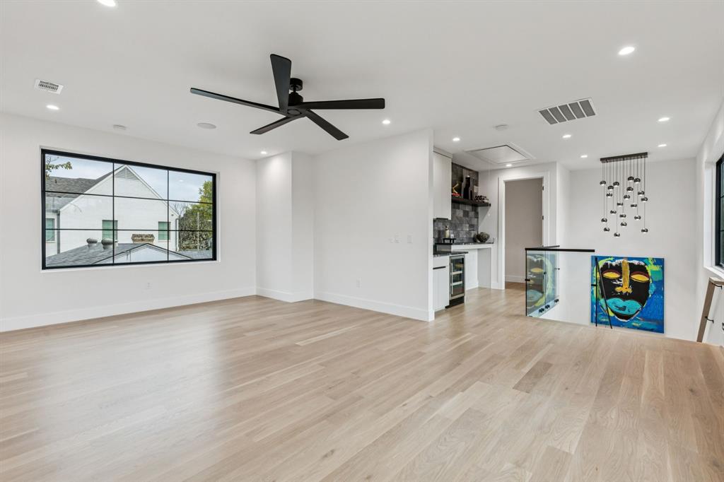 7707 Robin Road Dallas, TX 75209 - Photo 20 of 40 an empty room with wooden floor ceiling fan and windows