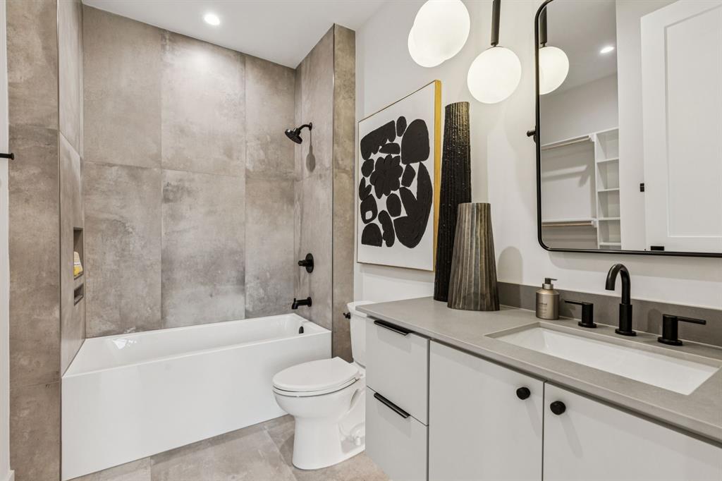 7707 Robin Road Dallas, TX 75209 - Photo 28 of 40 a bathroom with a granite countertop sink a toilet and bathtub
