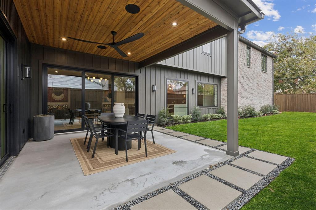 7707 Robin Road Dallas, TX 75209 - Photo 38 of 40 a view of a patio with dining table and chairs with a small yard