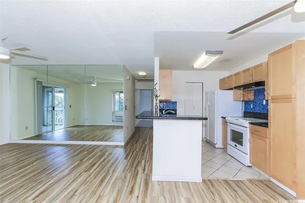 a large kitchen with cabinets wooden floor and stainless steel appliances