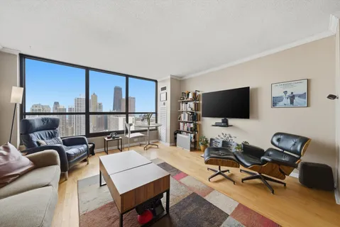 a living room with furniture a flat screen tv and a floor to ceiling window
