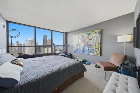 a spacious bedroom with a bed window and wall painting