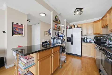 a kitchen with a refrigerator a stove top oven a clock and a center island