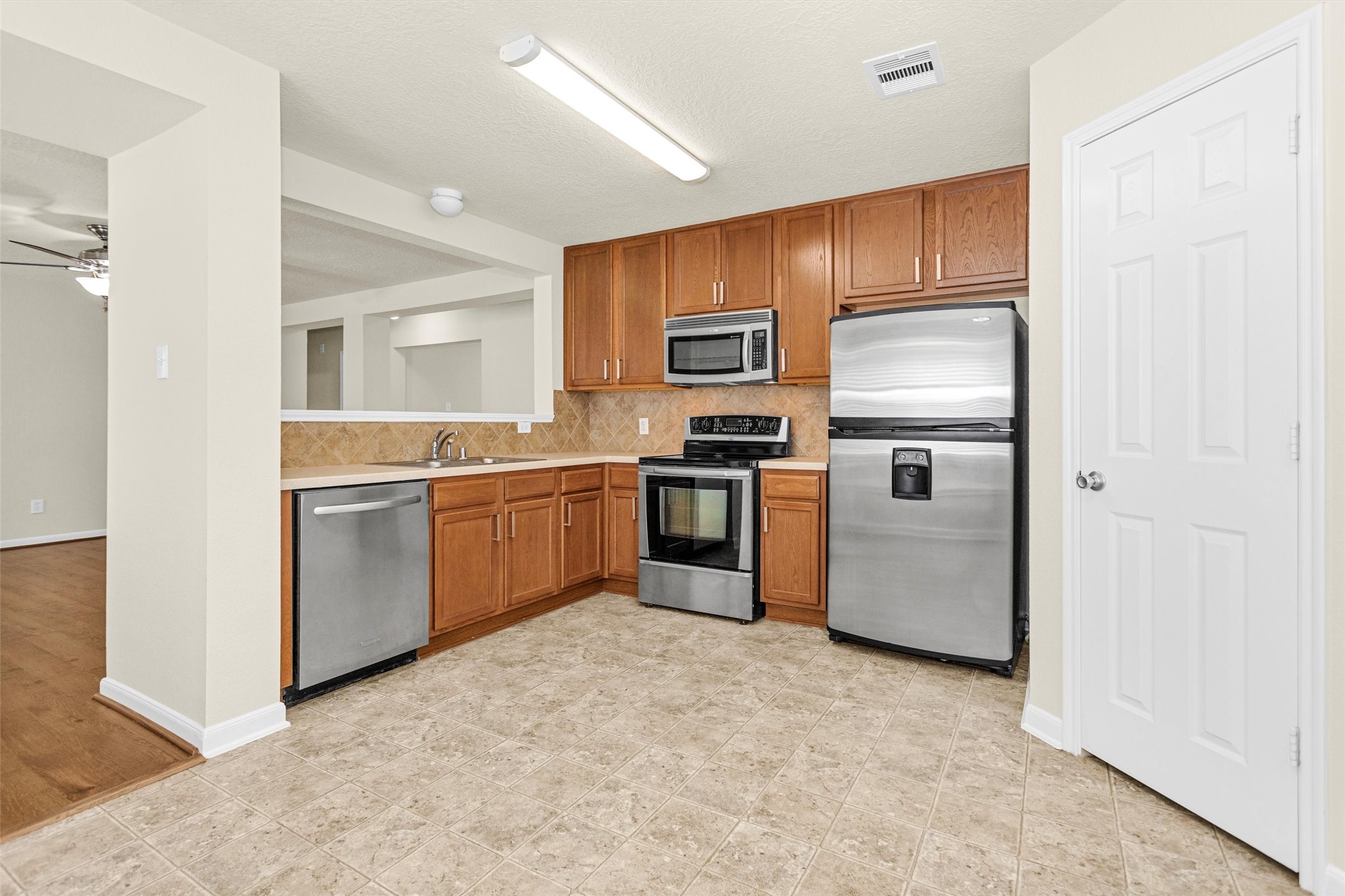 3131 Beacon Grove Street Spring, TX 77389 - Photo 12 of 38 a kitchen with a sink stainless steel appliances and cabinets