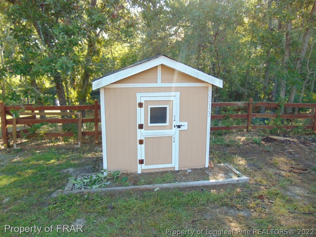 5313 Harding Drive Hope Mills, NC 28348 - Photo 18 of 26 a view of a small house in front of a yard with plants and large trees