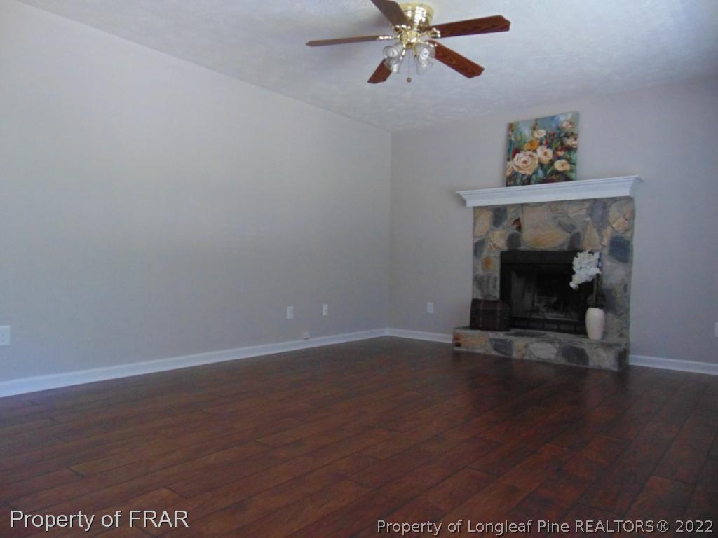 5313 Harding Drive Hope Mills, NC 28348 - Photo 4 of 26 a view of an empty room with wooden floor and a fireplace