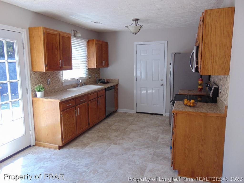 5313 Harding Drive Hope Mills, NC 28348 - Photo 7 of 26 a kitchen with a sink and a stove