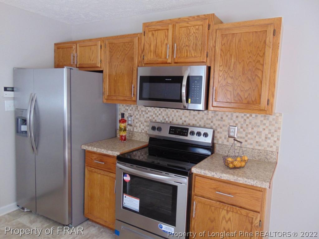 5313 Harding Drive Hope Mills, NC 28348 - Photo 8 of 26 a kitchen with stainless steel appliances granite countertop a stove microwave and refrigerator