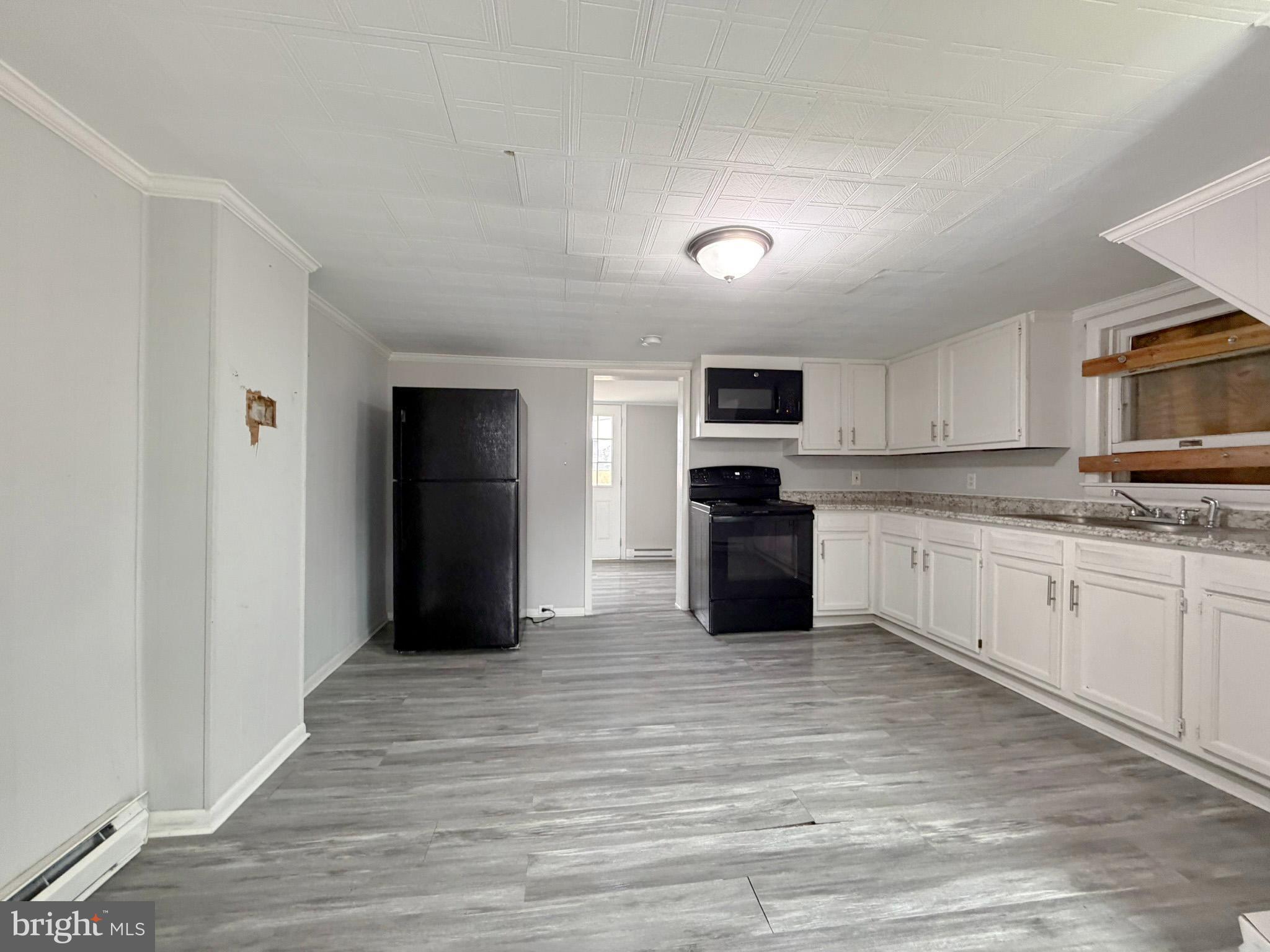 35534 Mt Hermon Road Pittsville, MD 21850 - Photo 12 of 52 a kitchen with granite countertop a refrigerator and a stove top oven
