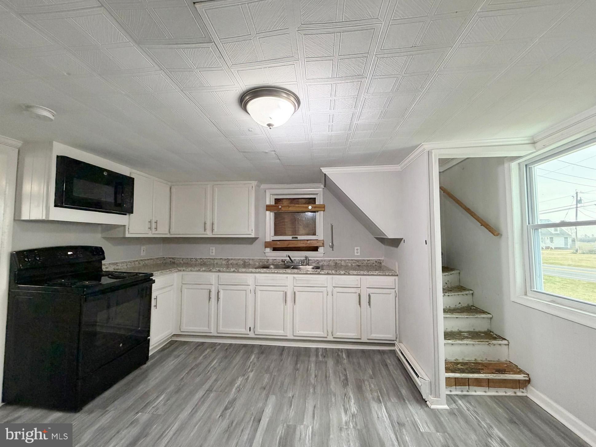 35534 Mt Hermon Road Pittsville, MD 21850 - Photo 16 of 52 a kitchen with granite countertop a stove a sink and a microwave
