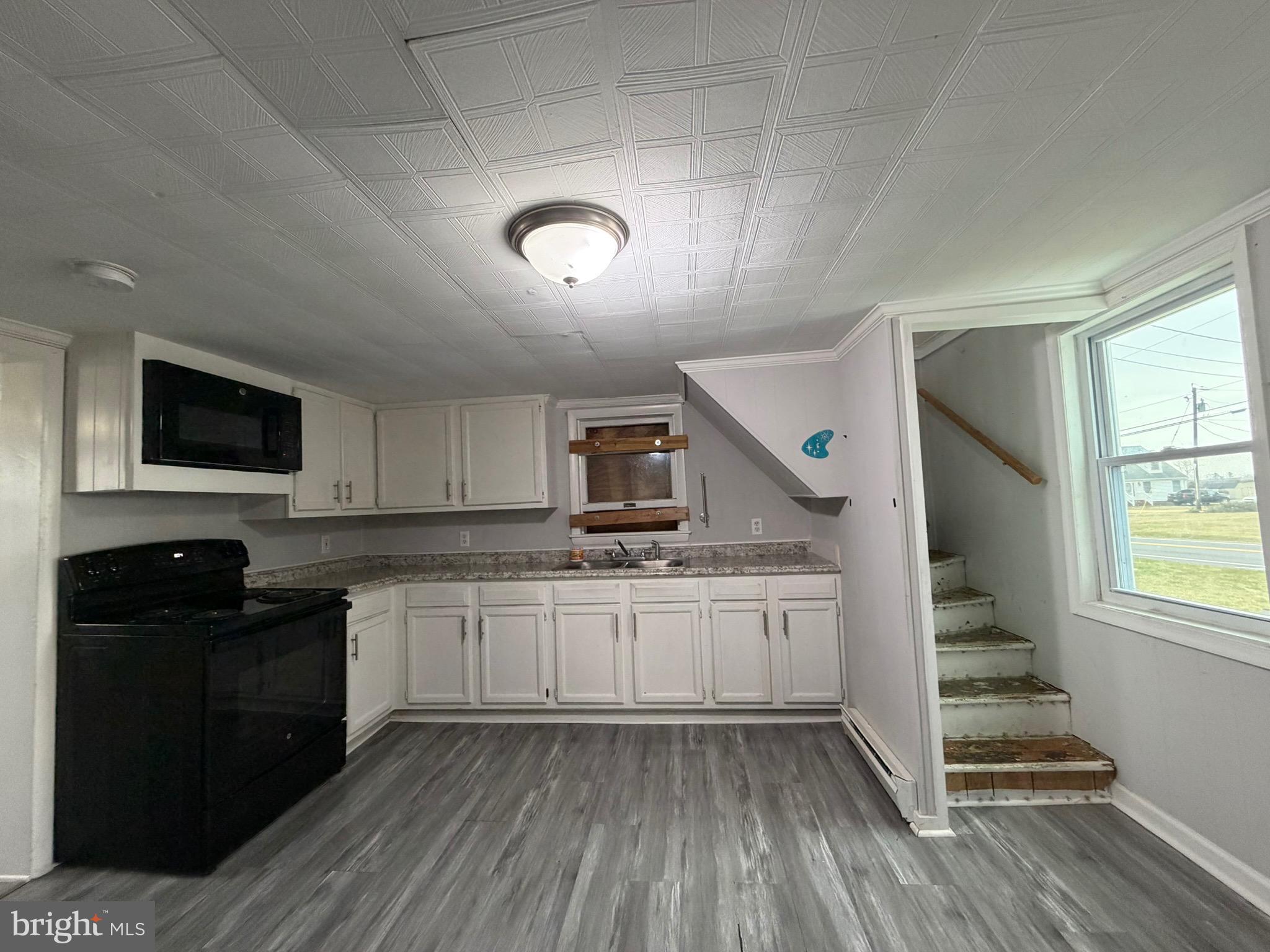 35534 Mt Hermon Road Pittsville, MD 21850 - Photo 41 of 52 a kitchen with granite countertop a stove a sink and a microwave