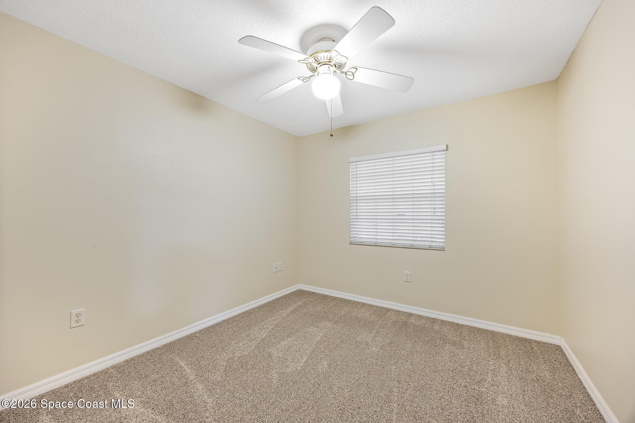 503 Arbor Ridge Lane Titusville, FL 32780 - Photo 26 of 38 an empty room with a chandelier fan and windows