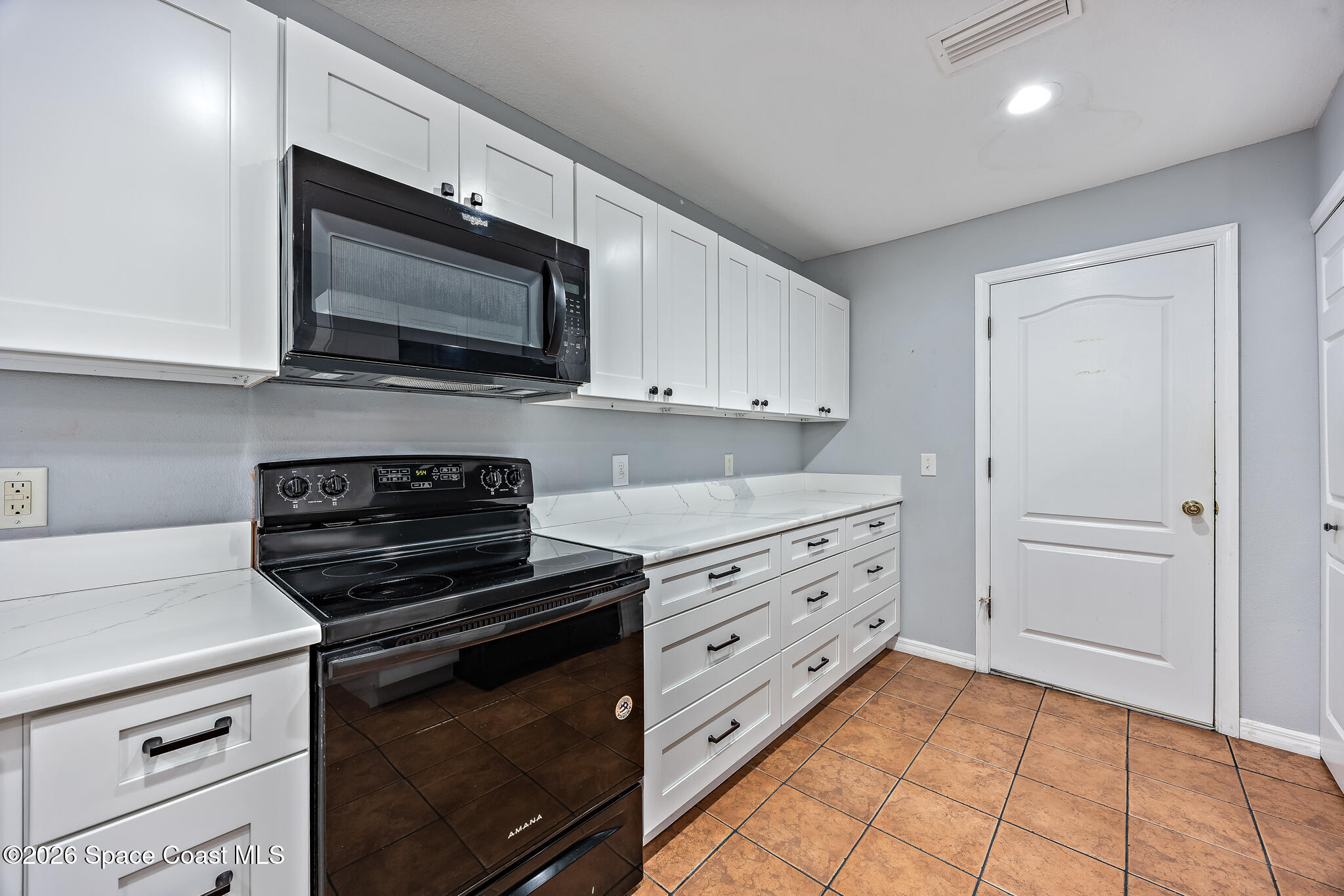 503 Arbor Ridge Lane Titusville, FL 32780 - Photo 5 of 38 a kitchen with granite countertop white cabinets and stainless steel appliances