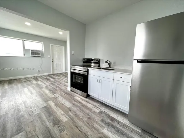 a kitchen with white cabinets and white appliances
