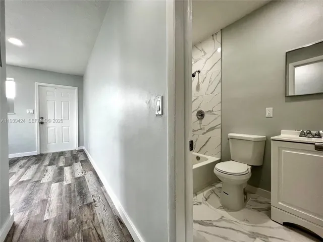 a view of a room with wooden floor