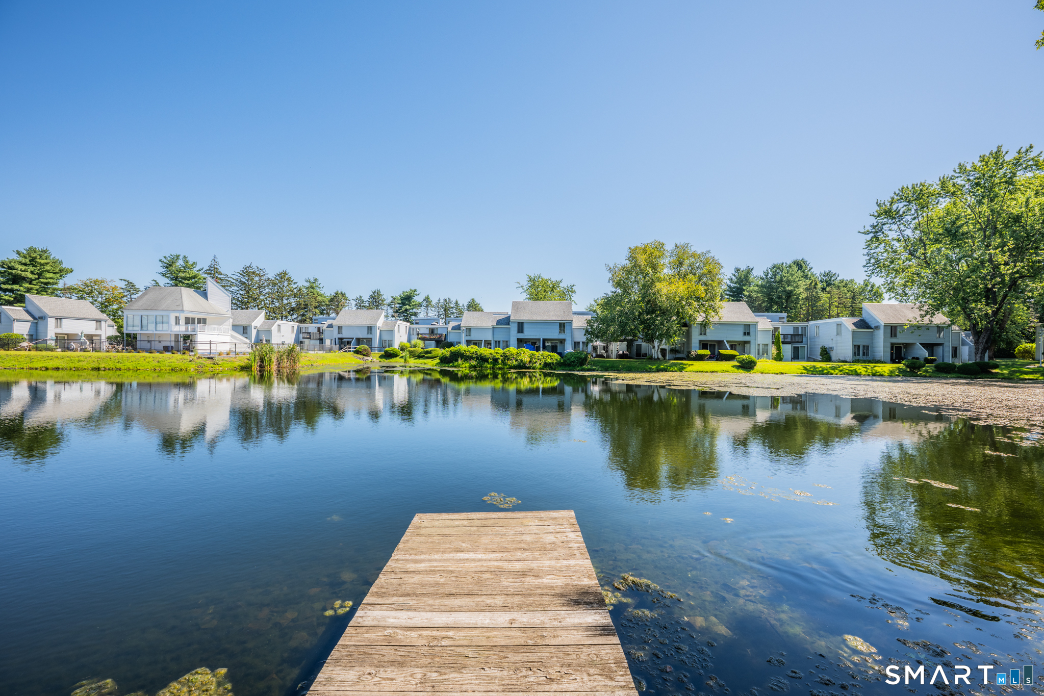 56 Cinnamon Spring, Unit 56 South Windsor, CT 06074 - Photo 29 of 31 a view of a lake with a table and chairs