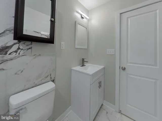 a bathroom with a toilet sink and mirror