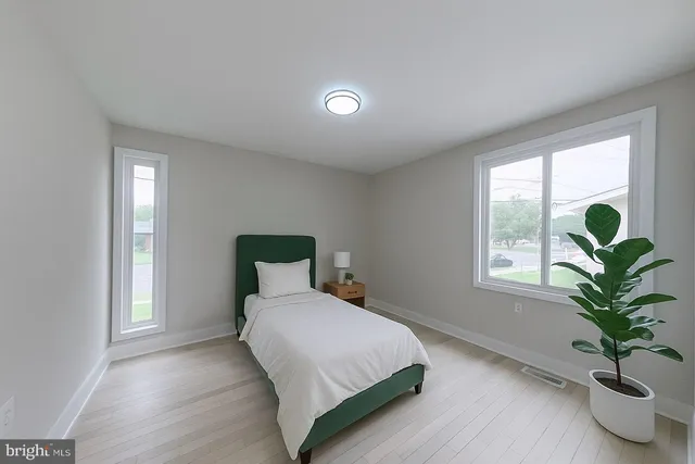 a bedroom with a bed and a potted plant