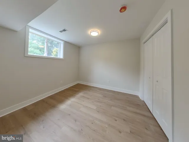 a view of empty room with wooden floor