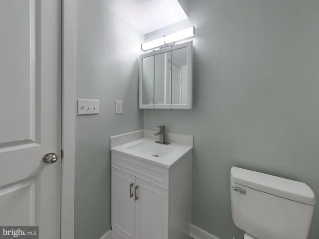 a bathroom with a toilet sink and mirror