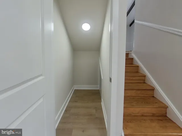 a view of a hallway with wooden floor and entryway