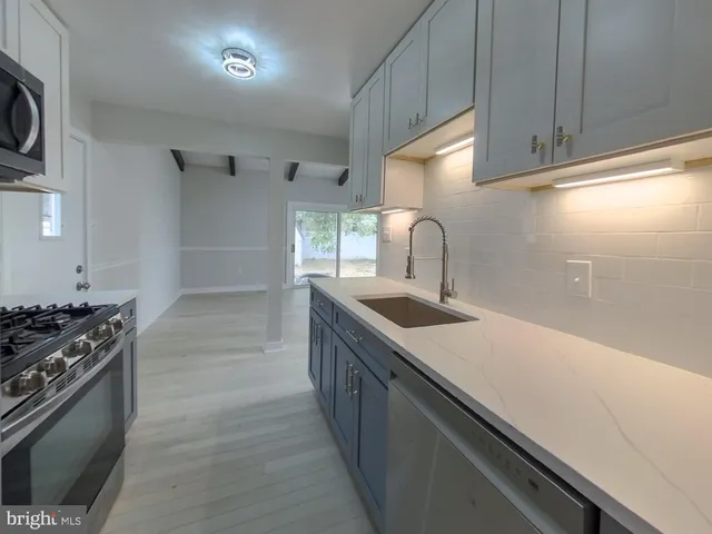 a kitchen with granite countertop a sink and a stove top oven