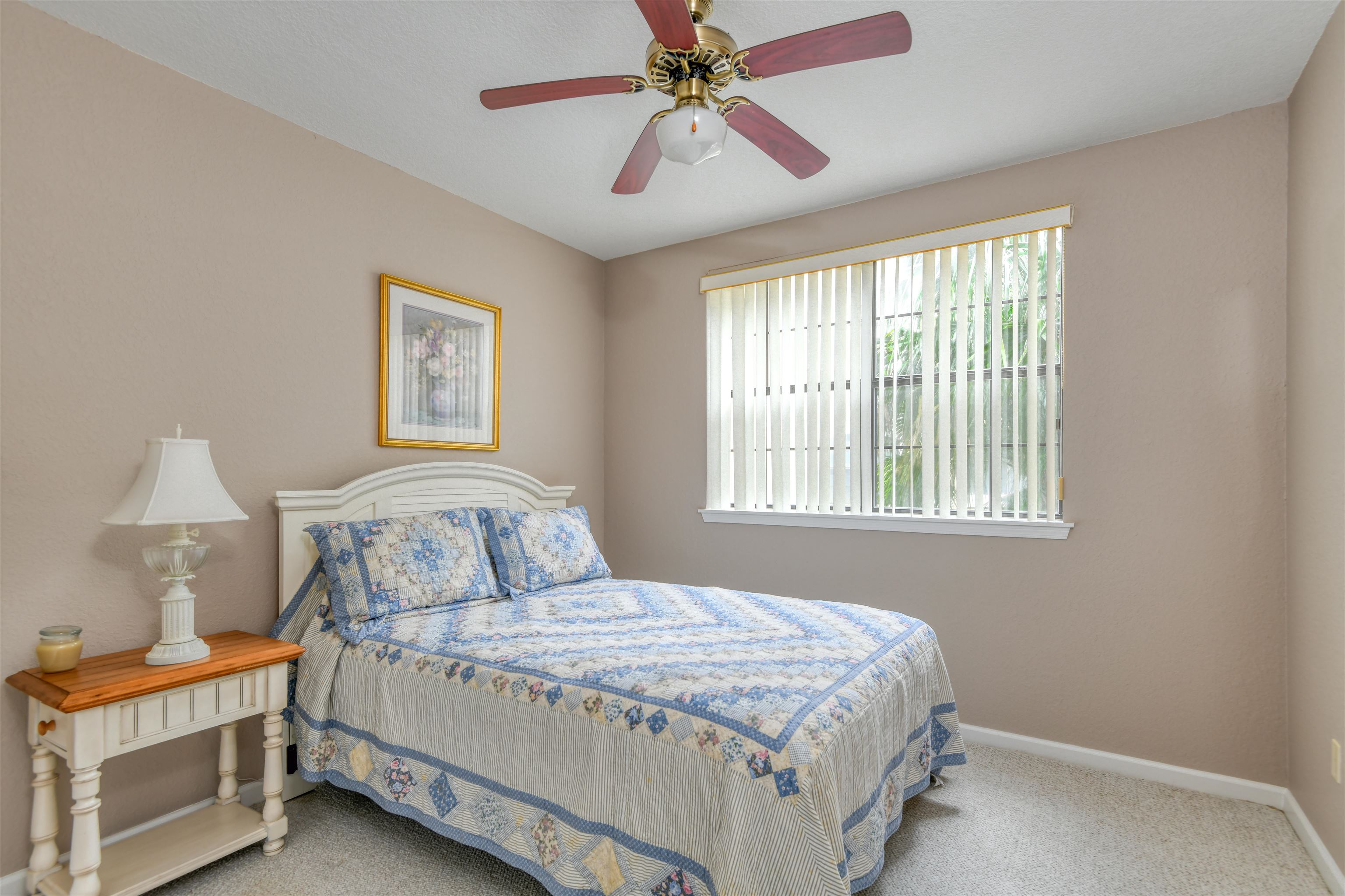 2202 Vista Cove Road St. Augustine, FL 32084 - Photo 15 of 38 a bedroom with a bed and a chandelier