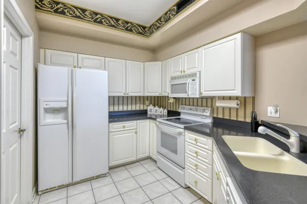 a kitchen with granite countertop a sink a counter top space stainless steel appliances and cabinets