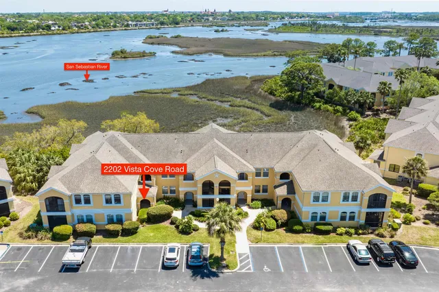 an aerial view of residential houses with outdoor space and ocean view