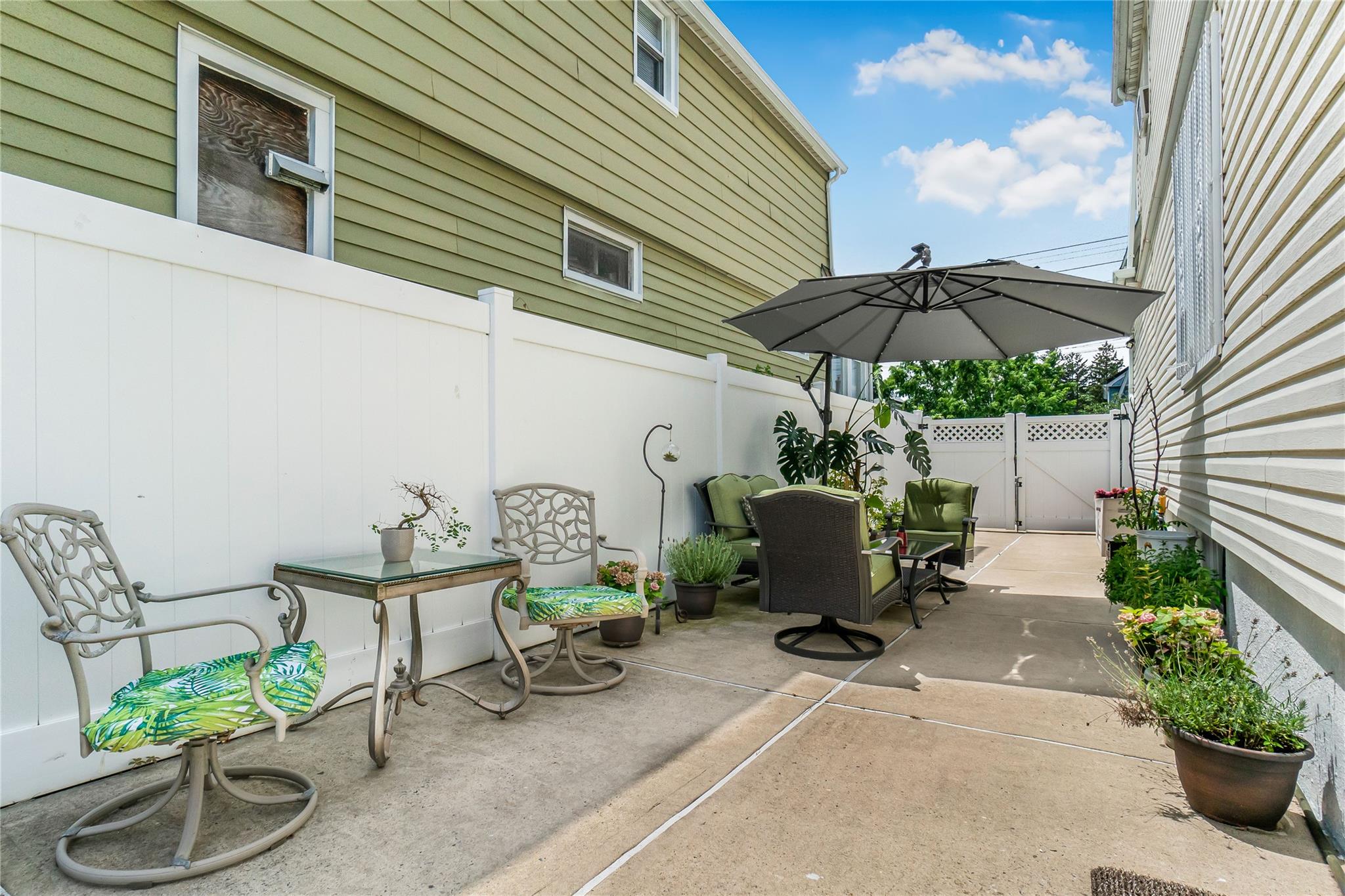 90-21 218th Place Queens, NY 11428 - Photo 14 of 21 a view of a patio with table and chairs under an umbrella