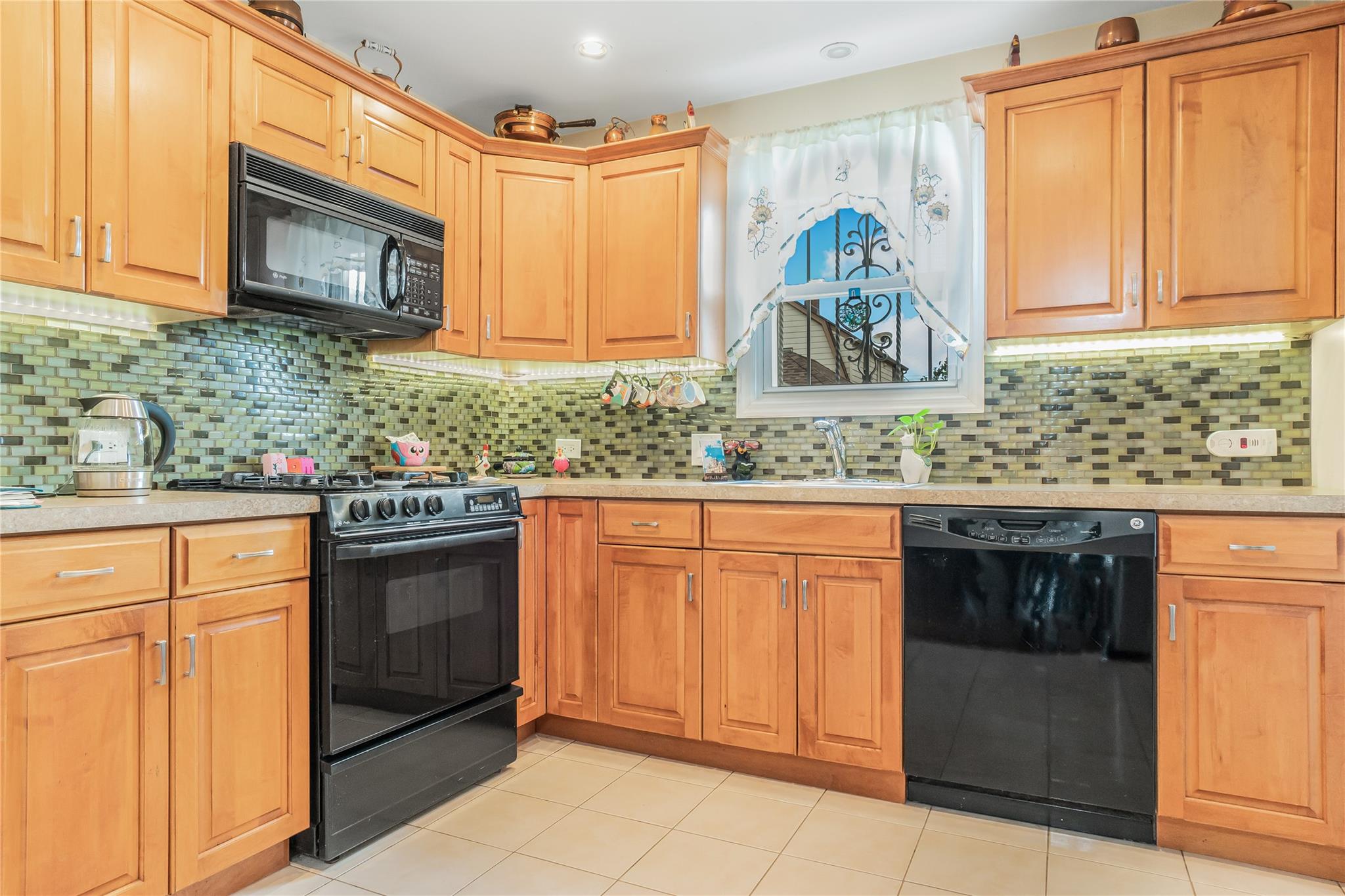 90-21 218th Place Queens, NY 11428 - Photo 6 of 21 a kitchen with stainless steel appliances granite countertop a stove a sink and a microwave