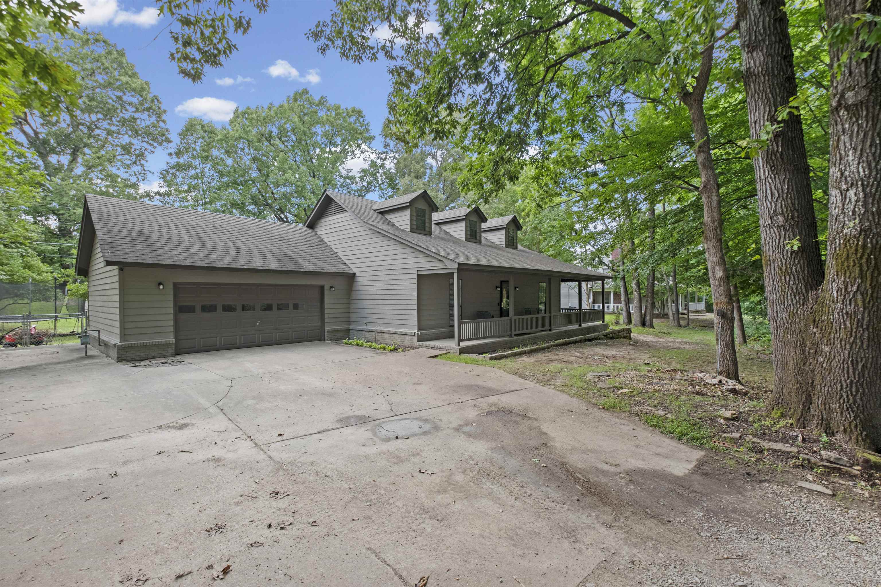 3601 Marshall Road Munford, TN 38058 - Photo 2 of 35 Exterior showcasing gray siding, a two-car garage with a paneled door, and a covered front porch