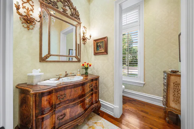 a front view of a house with a garden and lake